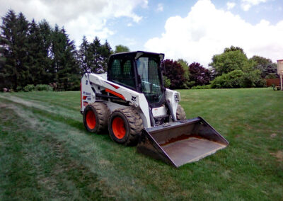 Bobcat Skid loader on green yard